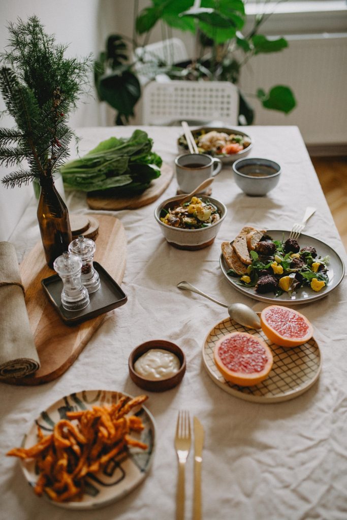 A decorated table with six plates of healthy food on it.